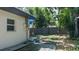 The backyard has a small stone patio, and the yard is enclosed by a wooden fence and trees at 1801 Marilyn Ave, Bradenton, FL 34207