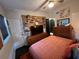 Cozy bedroom featuring a ceiling fan, salmon bedding, stylish decor, and ample storage at 1801 Marilyn Ave, Bradenton, FL 34207