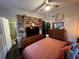 Cozy bedroom featuring a ceiling fan, salmon bedding, stylish decor, and ensuite bathroom at 1801 Marilyn Ave, Bradenton, FL 34207