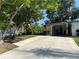 Home exterior featuring a convenient carport, manicured lawn, and a charming stone accent wall at 1801 Marilyn Ave, Bradenton, FL 34207