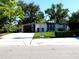 Charming single-story home with a well-manicured lawn and modern design, featuring mature trees and a spacious driveway at 1801 Marilyn Ave, Bradenton, FL 34207