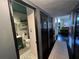 Hallway leading to a trendy powder room with gray walls, black accents, and unique flooring at 1801 Marilyn Ave, Bradenton, FL 34207