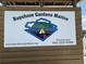 Close-up of the Bayshore Gardens Marina sign, providing contact information and website address at 1801 Marilyn Ave, Bradenton, FL 34207