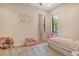 Bright bedroom featuring a unicorn wall decal, a small couch, and a bed with pink accents at 1813 Boyce St, Sarasota, FL 34239