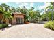 Charming home featuring a paved circular driveway, lush landscaping, and a secure gated entrance at 1813 Boyce St, Sarasota, FL 34239
