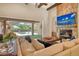 Bright living room featuring a stone fireplace and sliding glass doors to a screened patio with a pool at 1813 Boyce St, Sarasota, FL 34239