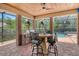 Covered outdoor dining area with brick columns, bar seating, built-in grill, and view of the pool at 1813 Boyce St, Sarasota, FL 34239