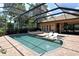 Private backyard pool area featuring a built-in spa, lounge chairs, and a screened enclosure at 1813 Boyce St, Sarasota, FL 34239