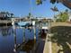 Scenic canal view with a blue sailboat, boat lift, and lush, tropical landscaping at 191 Maria Ct, Punta Gorda, FL 33950