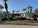 Inviting single-story home features a manicured lawn with palm trees and white exterior at 191 Maria Ct, Punta Gorda, FL 33950