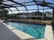 Relaxing screened-in pool with crystal-clear water, surrounded by lush landscaping and canal views at 191 Maria Ct, Punta Gorda, FL 33950