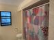Shower with eye-catching curtain and tile walls with a window and toilet nearby at 191 Maria Ct, Punta Gorda, FL 33950