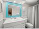 Updated bathroom featuring a white vanity, turquoise framed mirror, and shower with tub at 1915 38Th W St, Bradenton, FL 34205