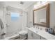 Bright bathroom with white tiled shower, large window and vanity with decorative mirror at 1915 38Th W St, Bradenton, FL 34205