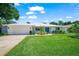 Well-maintained home exterior with a lush green lawn, freshly painted white brick, and a convenient two-car garage at 1915 38Th W St, Bradenton, FL 34205