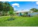 Beautiful front yard featuring a lush green lawn, manicured landscaping, and a white brick home exterior at 1915 38Th W St, Bradenton, FL 34205