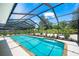 Covered pool with brick coping, screened in lanai, and professionally landscaped surrounding the pool at 1915 38Th W St, Bradenton, FL 34205