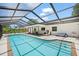 Inviting screened-in pool with patio furniture, white brick and lush landscaping at 1915 38Th W St, Bradenton, FL 34205