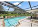 Beautiful screened-in pool area with a brick surround, patio furniture and lush landscaping at 1915 38Th W St, Bradenton, FL 34205