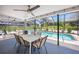 Screened patio with a dining table and view of a large pool with tropical landscaping at 1915 38Th W St, Bradenton, FL 34205