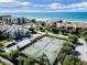 Aerial view showcasing community tennis courts, beach access, and well-maintained landscaping for an active lifestyle at 2045 Gulf Of Mexico Dr # M1-515, Longboat Key, FL 34228