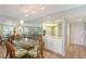 Bright dining room featuring a glass table, seating for six, and a mirrored wall with kitchen access at 2045 Gulf Of Mexico Dr # M1-515, Longboat Key, FL 34228