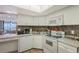 Bright kitchen with white cabinetry, tile backsplash, and modern appliances with views to the ocean beyond at 2045 Gulf Of Mexico Dr # M1-515, Longboat Key, FL 34228
