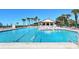 Community pool with clear blue water, lounge chairs and umbrellas on a sunny day at 2045 Gulf Of Mexico Dr # M1-515, Longboat Key, FL 34228