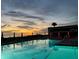 Resort-style pool area reflecting a colorful sunset, with lounge chairs and umbrellas, creating a serene setting at 2045 Gulf Of Mexico Dr # M1-515, Longboat Key, FL 34228