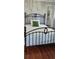 Bedroom boasts hardwood floors, an iron bed, and a serene window view at 219 24Th W St, Bradenton, FL 34205