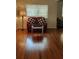 Cozy living room showcasing hardwood floors, a red sofa, and a lamp at 219 24Th W St, Bradenton, FL 34205