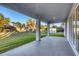 Covered outdoor patio provides relaxing area with view of fenced yard and mature trees at 2323 Zuyder Ter, North Port, FL 34286