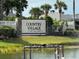 Sign for the 55+ Country Village Community, situated by a pond, with lush greenery at 2841 74Th St W # 2841, Bradenton, FL 34209