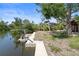 Canal-front view with a private dock and boat lift, framed by lush landscaping at 30 Island Cir, Sarasota, FL 34242