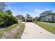 Long concrete driveway leading to the two car garage with lush tropical foliage at 30 Island Cir, Sarasota, FL 34242