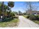 Long driveway with mature trees leads to a cozy home with a two-car garage at 30 Island Cir, Sarasota, FL 34242