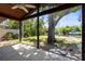 Screened in patio with views of lush green backyard, canal, and boat dock at 30 Island Cir, Sarasota, FL 34242