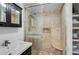 Modern bathroom with glass shower, wood-style tile, and built-in shelving for storage at 301 W South Ave, Tampa, FL 33603