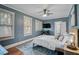 Blue bedroom features hardwood floors, a ceiling fan, and natural light at 301 W South Ave, Tampa, FL 33603