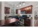 Functional kitchen featuring dark wood cabinetry, stainless steel appliances, and granite countertops at 301 W South Ave, Tampa, FL 33603