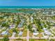 Breathtaking aerial view of a waterfront community with turquoise waters and lush greenery at 302 Pavonia Rd, Nokomis, FL 34275