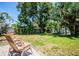 Spacious backyard featuring well-maintained grass, mature trees, and a charming patio area at 302 Pavonia Rd, Nokomis, FL 34275