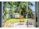 Cozy backyard patio with wicker chairs and a view of the lush, tropical backyard at 302 Pavonia Rd, Nokomis, FL 34275