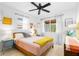 Cozy bedroom featuring a ceiling fan, light-filled windows with sheer curtains, and vintage-style decor at 302 Pavonia Rd, Nokomis, FL 34275