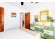 Sunlit bedroom showcasing a dresser, colorful decor, and wood-look doors at 302 Pavonia Rd, Nokomis, FL 34275