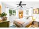 Cozy bedroom featuring a ceiling fan, and a sunlit window that overlooks the lush exterior at 302 Pavonia Rd, Nokomis, FL 34275