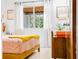 Bright bedroom with a wooden bed frame, terrazzo floors, and large windows for natural light at 302 Pavonia Rd, Nokomis, FL 34275