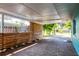 Spacious carport featuring brick pavers, wood privacy screen, and a view of the lush landscaping at 302 Pavonia Rd, Nokomis, FL 34275
