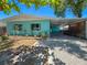 Charming turquoise home featuring a covered carport and well-maintained landscaping at 302 Pavonia Rd, Nokomis, FL 34275