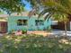 Cozy turquoise home with well-manicured landscaping including small plants, grass, and a carport at 302 Pavonia Rd, Nokomis, FL 34275